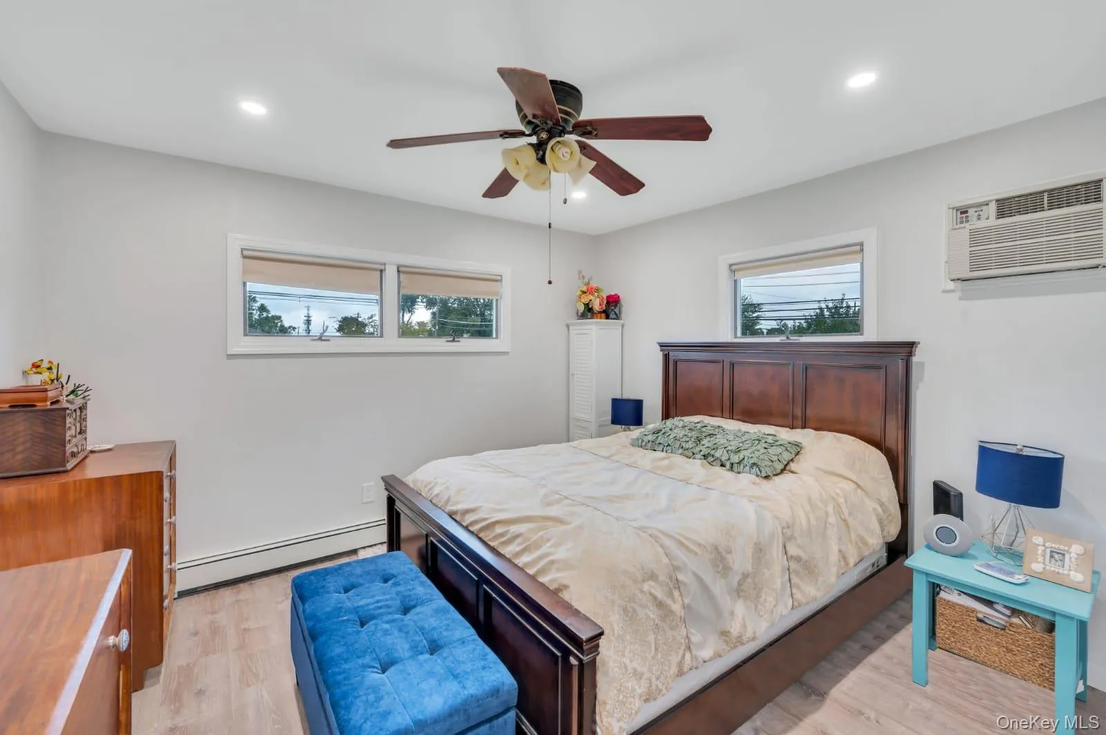 Bedroom featuring baseboard heating, light wood finished floors, multiple windows, recessed lighting, and ceiling fan Bedroom featuring baseboard heating, light wood finished floors, multiple windows, recessed lighting, and ceiling fan