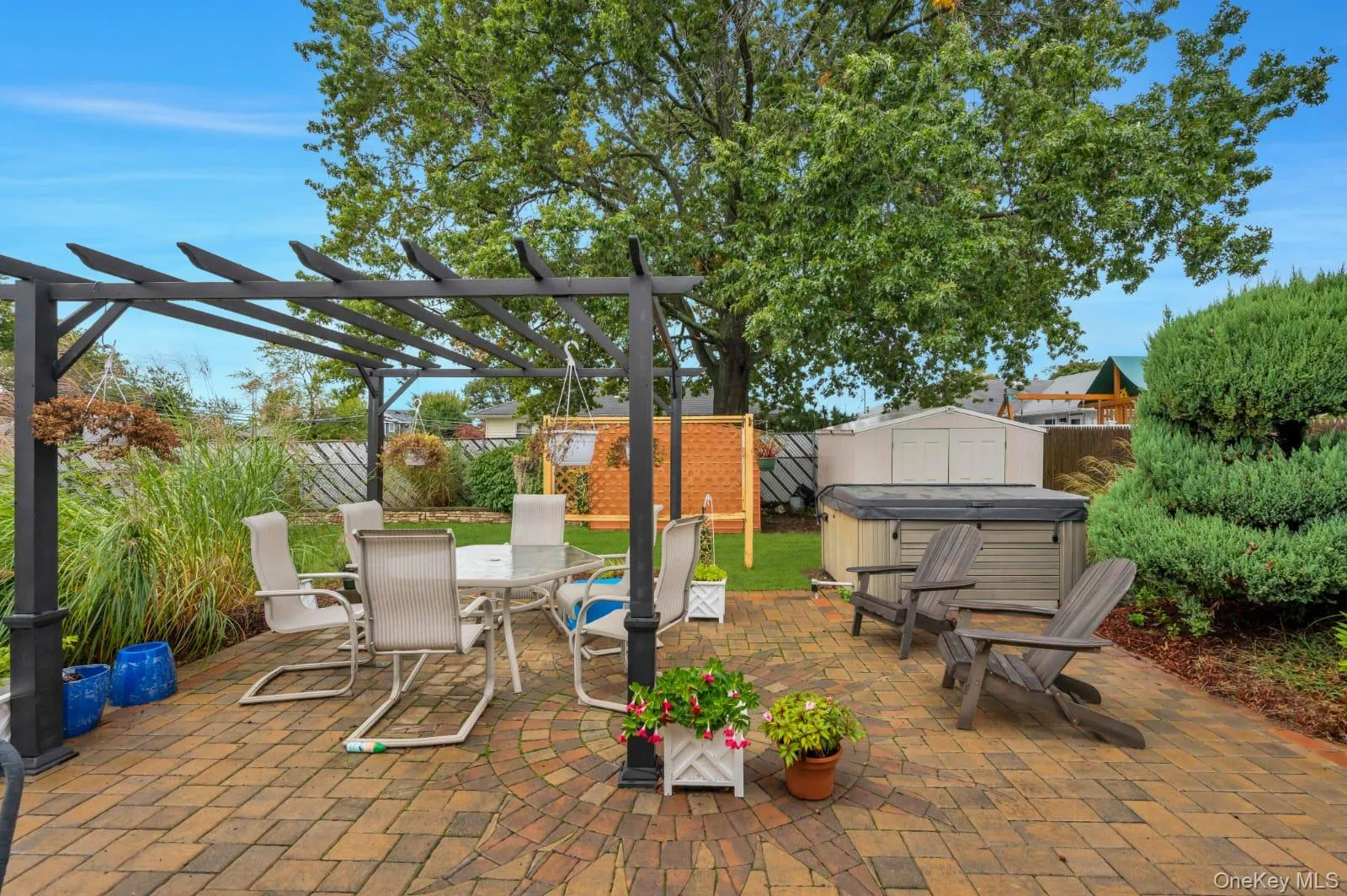 Fenced backyard featuring a hot tub, outdoor dining area, a patio, a pergola, and a storage shed Fenced backyard featuring a hot tub, outdoor dining area, a patio, a pergola, and a storage shed