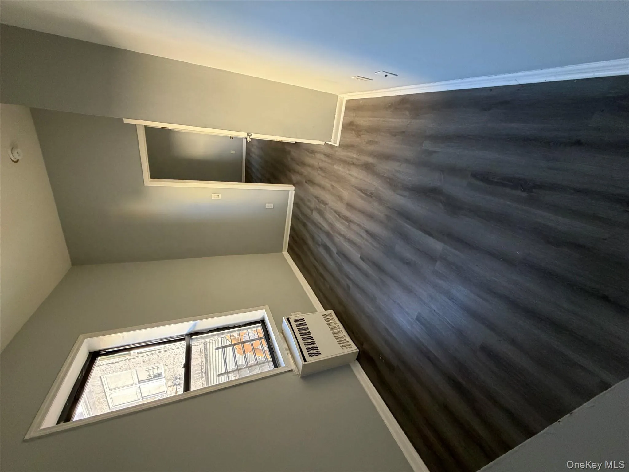 Spare room featuring dark wood-style floors and baseboards Spare room featuring dark wood-style floors and baseboards