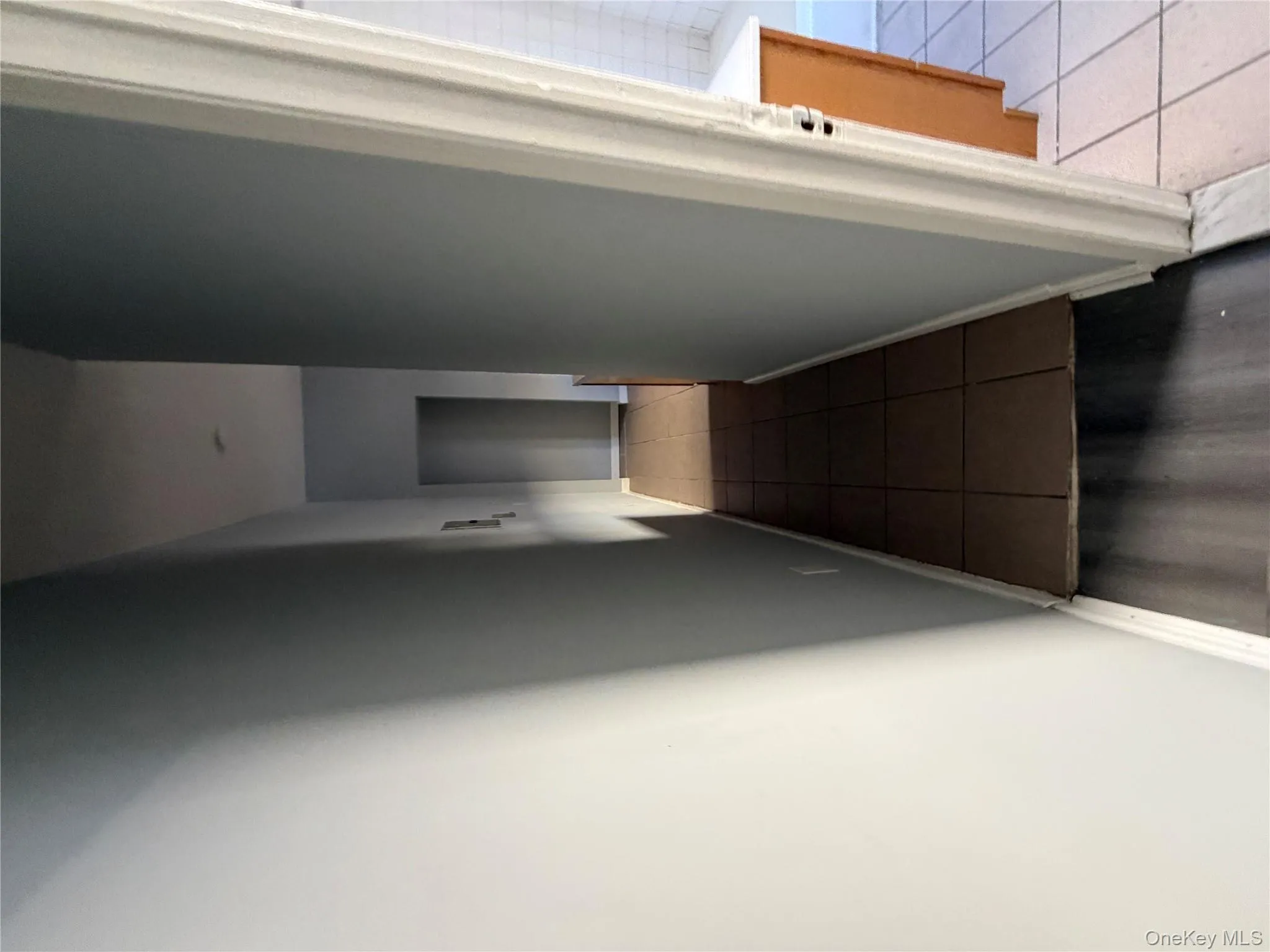 Hall featuring dark tile patterned floors and baseboards Hall featuring dark tile patterned floors and baseboards