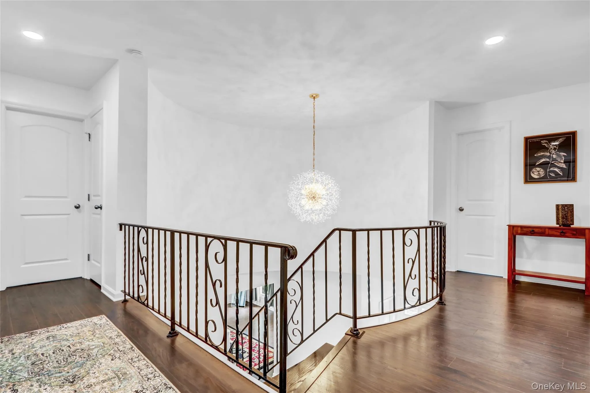 Hall with a chandelier, recessed lighting, dark wood-type flooring, and an upstairs landing Hall with a chandelier, recessed lighting, dark wood-type flooring, and an upstairs landing