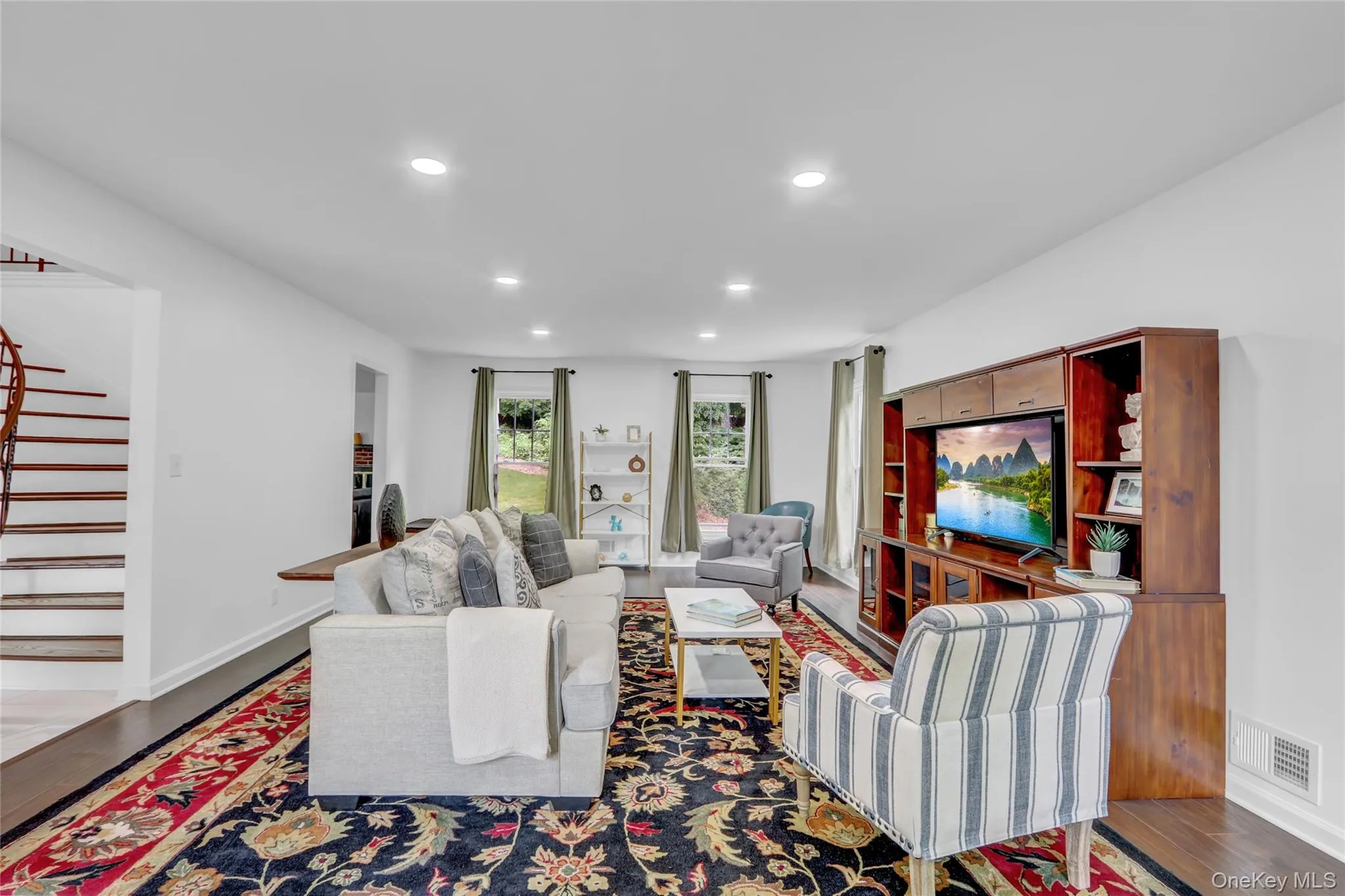 Living area with wood finished floors, stairs, and recessed lighting Living area with wood finished floors, stairs, and recessed lighting
