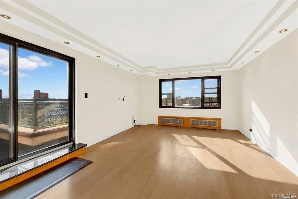 Unfurnished room featuring a tray ceiling, wood-type flooring, and recessed lighting Unfurnished room featuring a tray ceiling, wood-type flooring, and recessed lighting