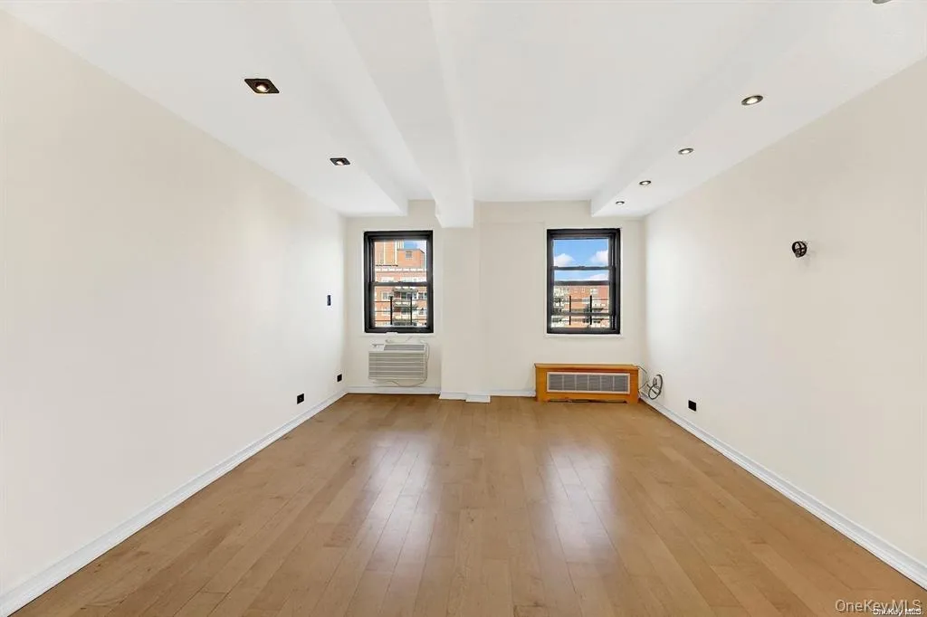 Unfurnished room with light wood-style floors, beam ceiling, and recessed lighting Unfurnished room with light wood-style floors, beam ceiling, and recessed lighting