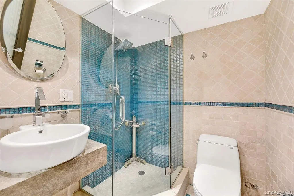 Bathroom with tile walls, a stall shower, and backsplash Bathroom with tile walls, a stall shower, and backsplash