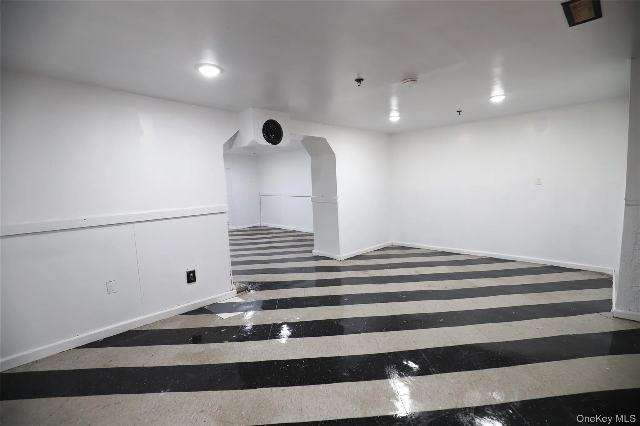 Spare room with inlaid floor details and baseboards Spare room with inlaid floor details and baseboards