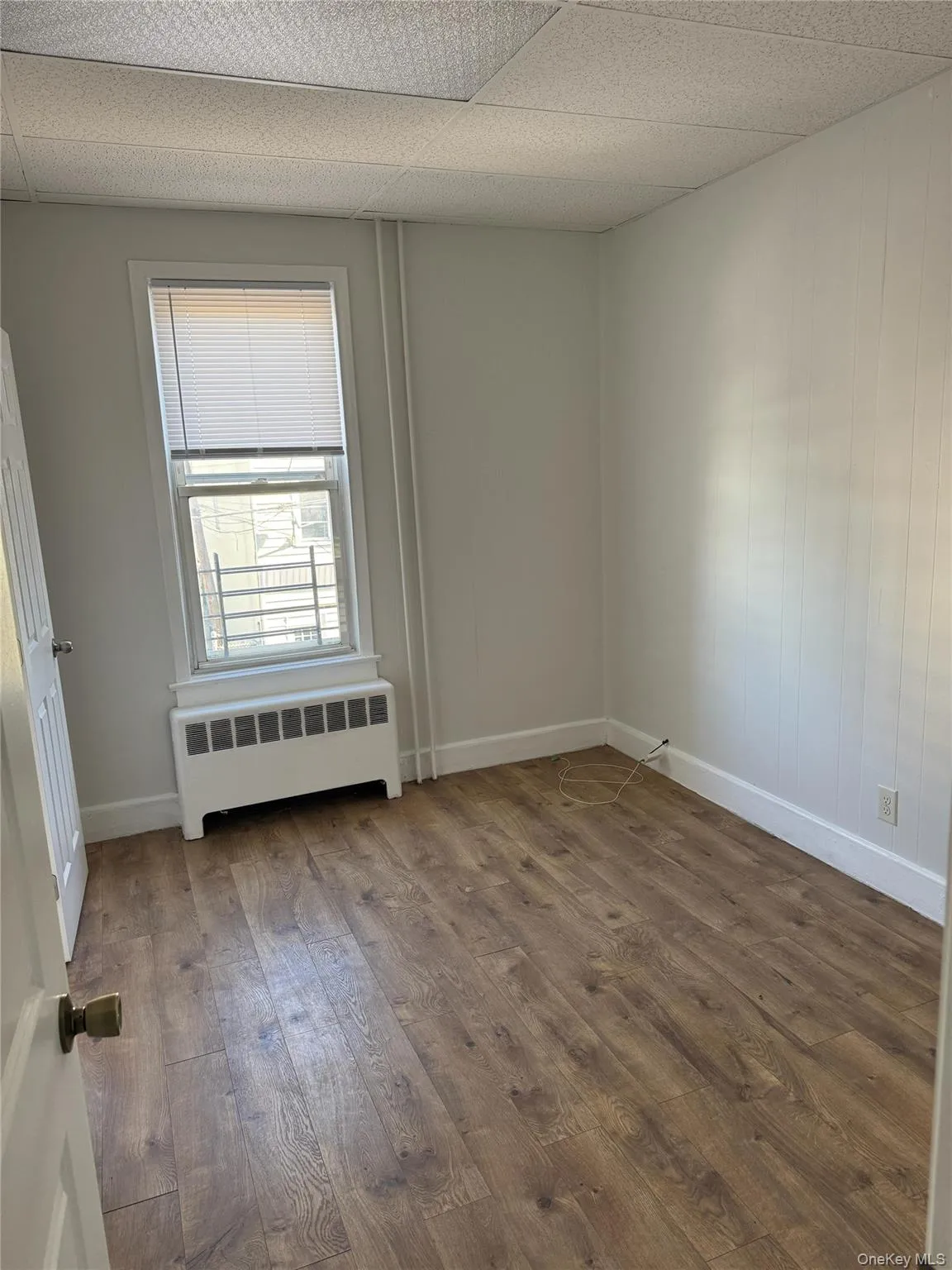 Empty room featuring dark wood-type flooring and radiator Empty room featuring dark wood-type flooring and radiator
