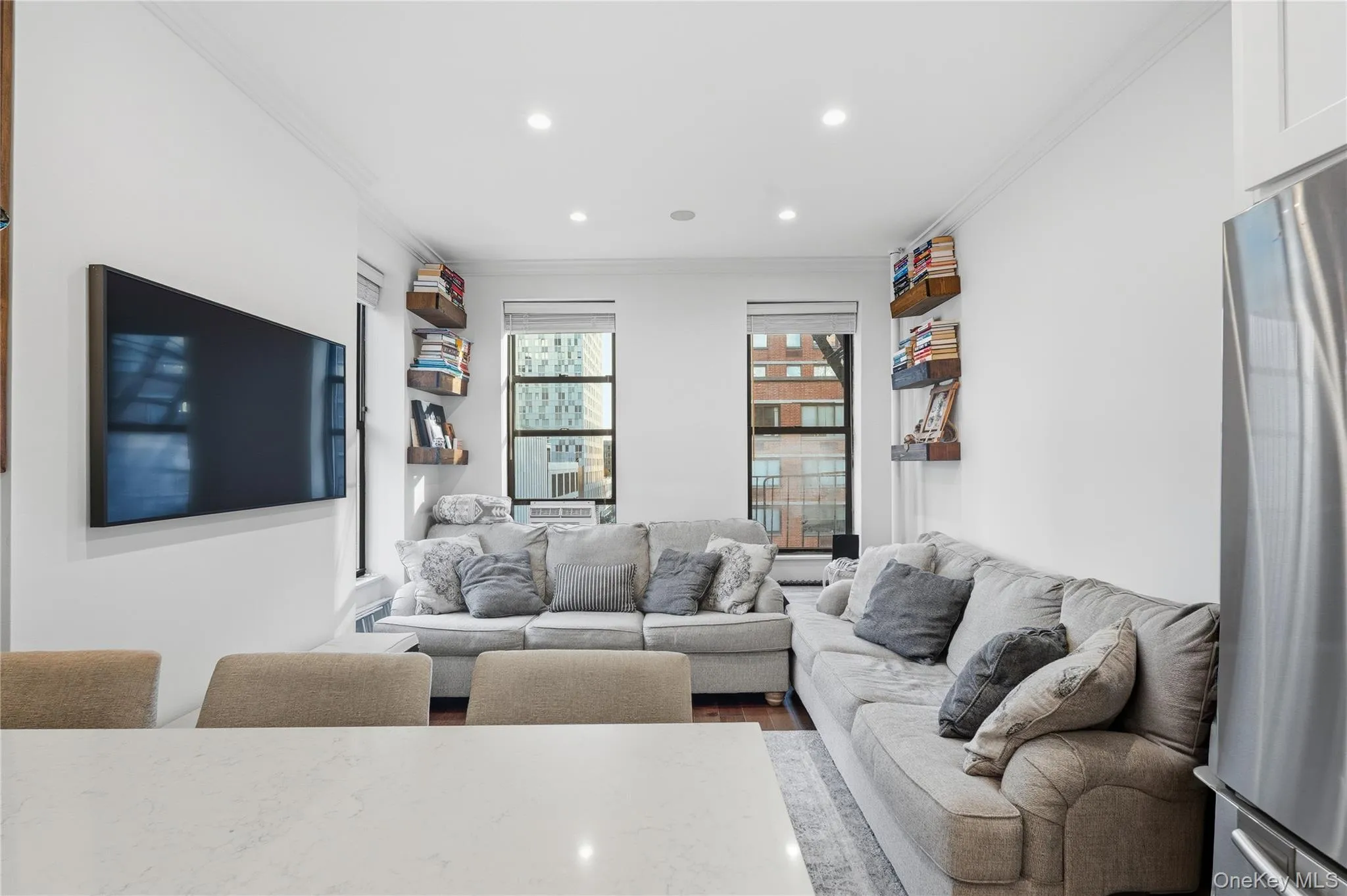 Living room featuring ornamental molding, dark wood-style floors, and recessed lighting Living room featuring ornamental molding, dark wood-style floors, and recessed lighting