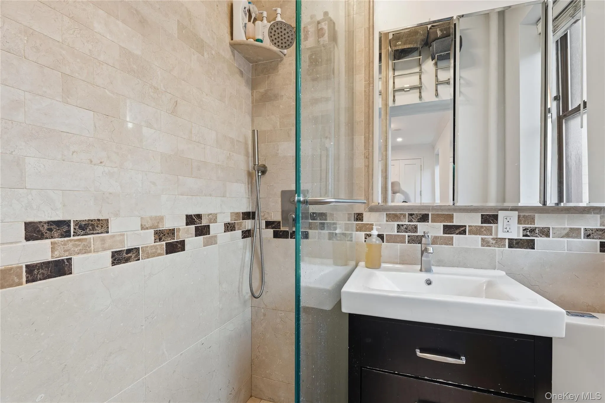 Full bath with tiled shower, vanity, backsplash, and tile walls Full bath with tiled shower, vanity, backsplash, and tile walls