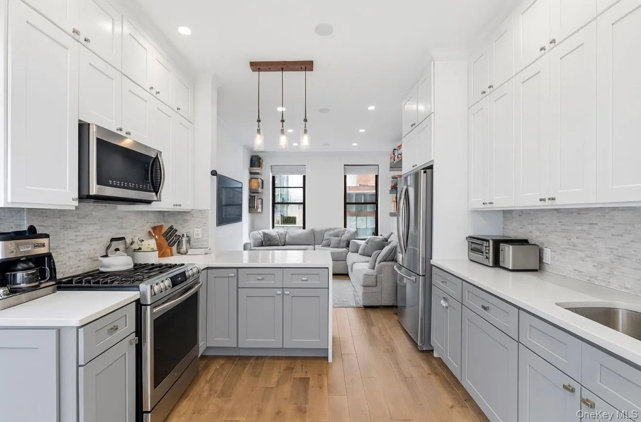 Kitchen featuring decorative backsplash, gray cabinets, appliances with stainless steel finishes, and recessed lighting Kitchen featuring decorative backsplash, gray cabinets, appliances with stainless steel finishes, and recessed lighting