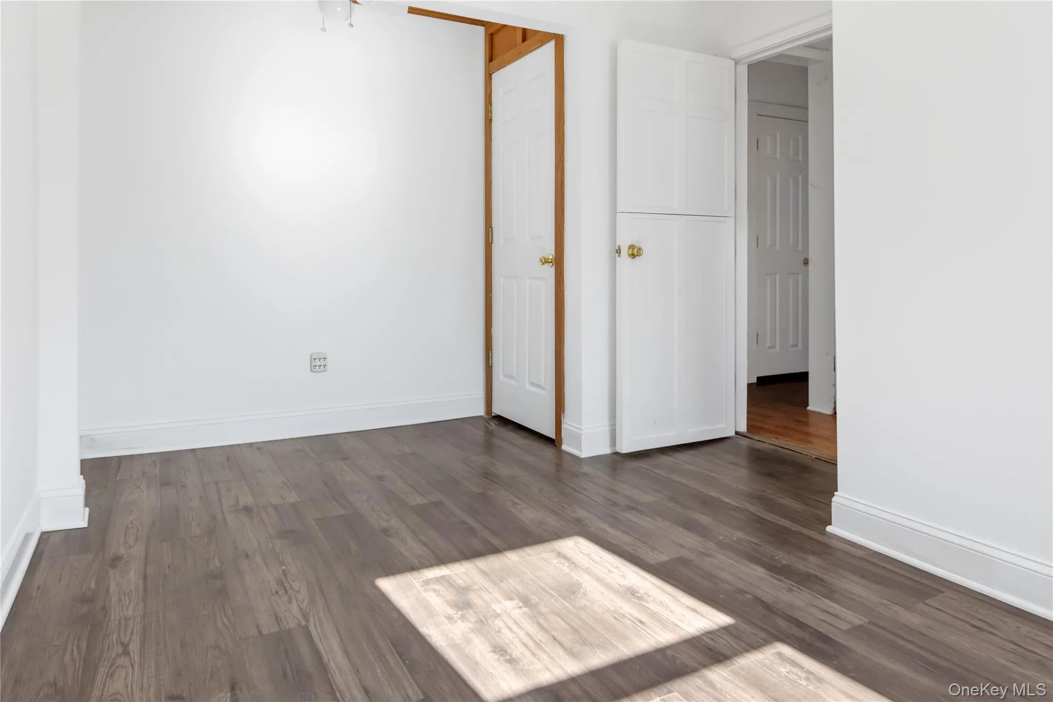 Unfurnished bedroom featuring dark wood-style floors Unfurnished bedroom featuring dark wood-style floors