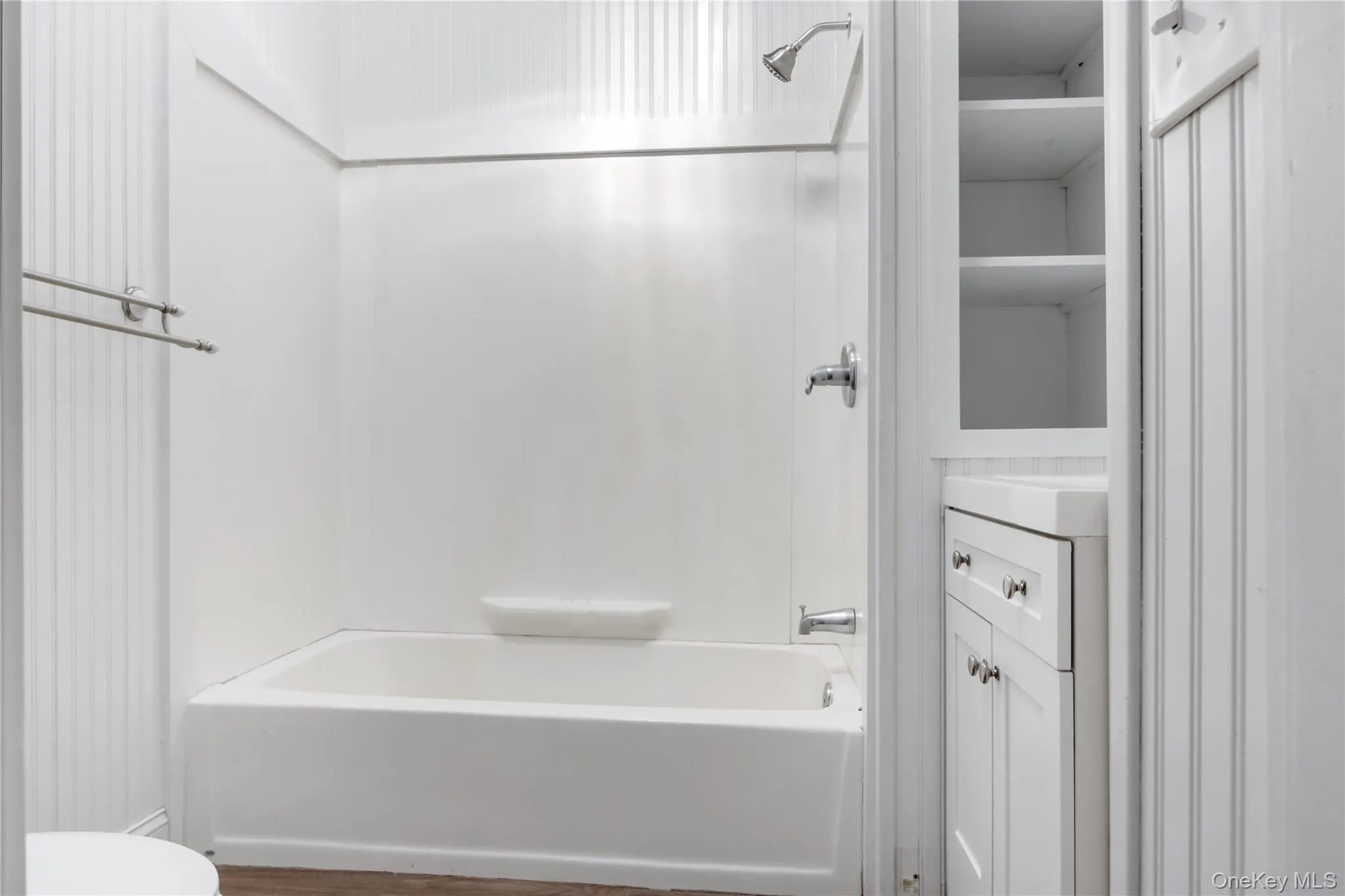 Bathroom featuring bathing tub / shower combination, vanity, and dark wood-type flooring Bathroom featuring bathing tub / shower combination, vanity, and dark wood-type flooring