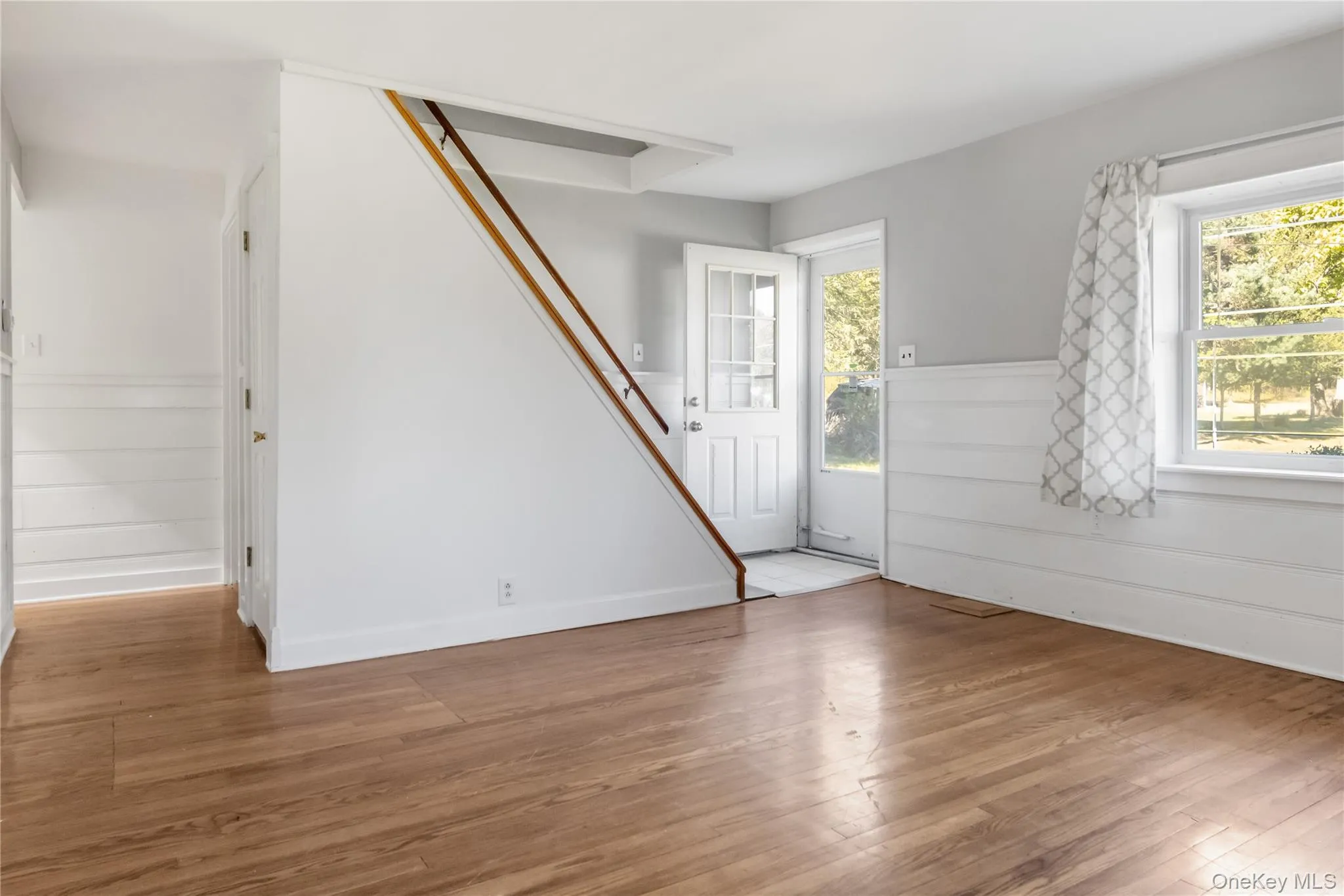 Foyer entrance with wainscoting and light wood finished floors Foyer entrance with wainscoting and light wood finished floors