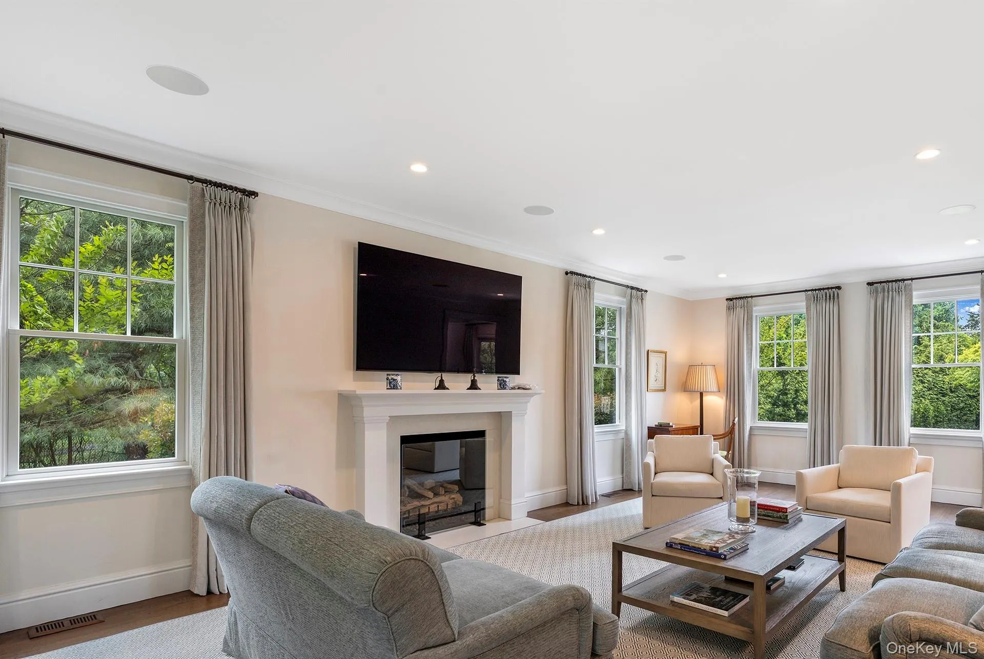 Living area with crown molding, a fireplace with flush hearth, and recessed lighting Living area with crown molding, a fireplace with flush hearth, and recessed lighting