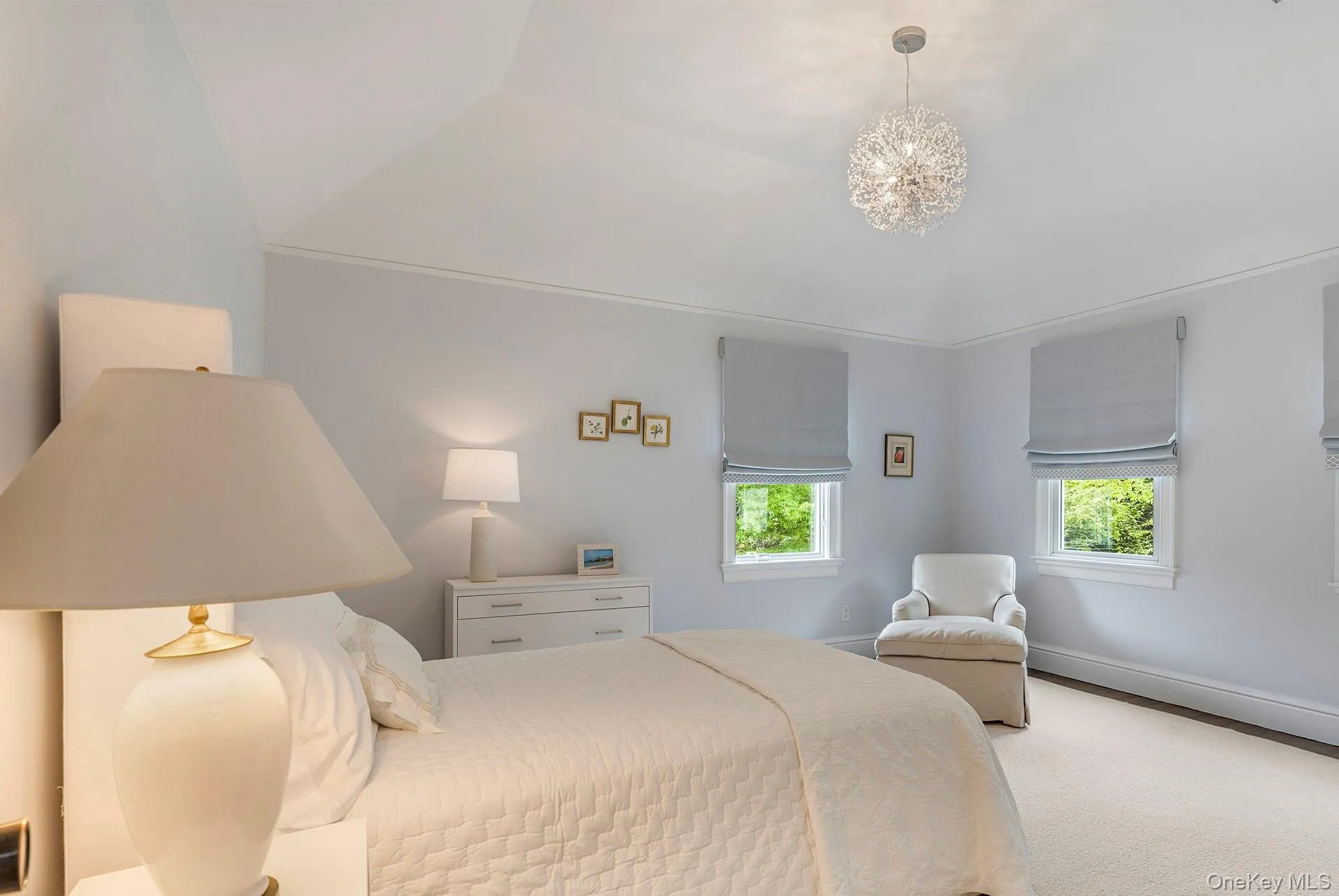 Carpeted bedroom with multiple windows and a chandelier Carpeted bedroom with multiple windows and a chandelier