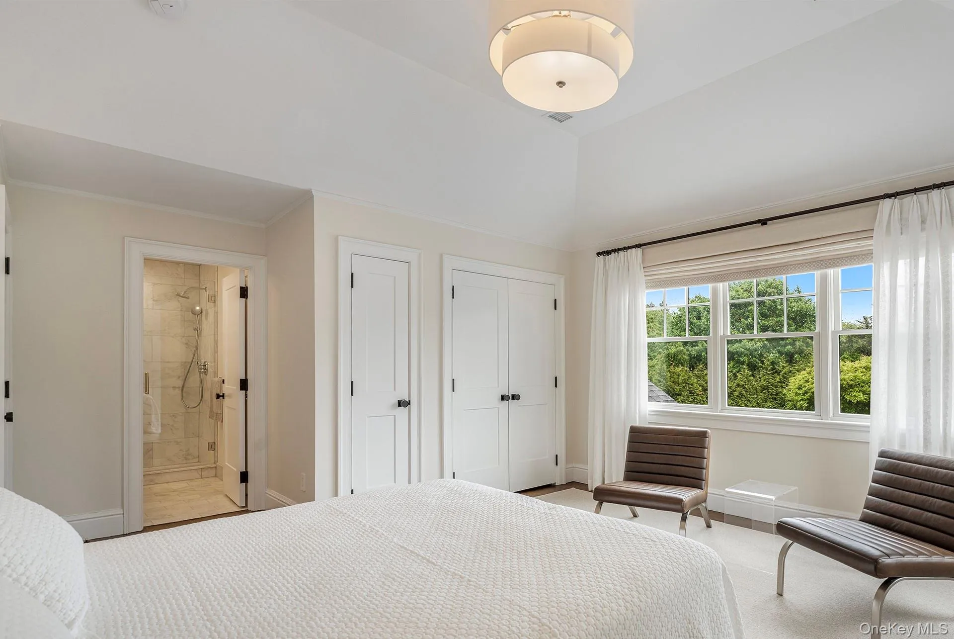 Bedroom featuring multiple closets, connected bathroom, and ornamental molding Bedroom featuring multiple closets, connected bathroom, and ornamental molding