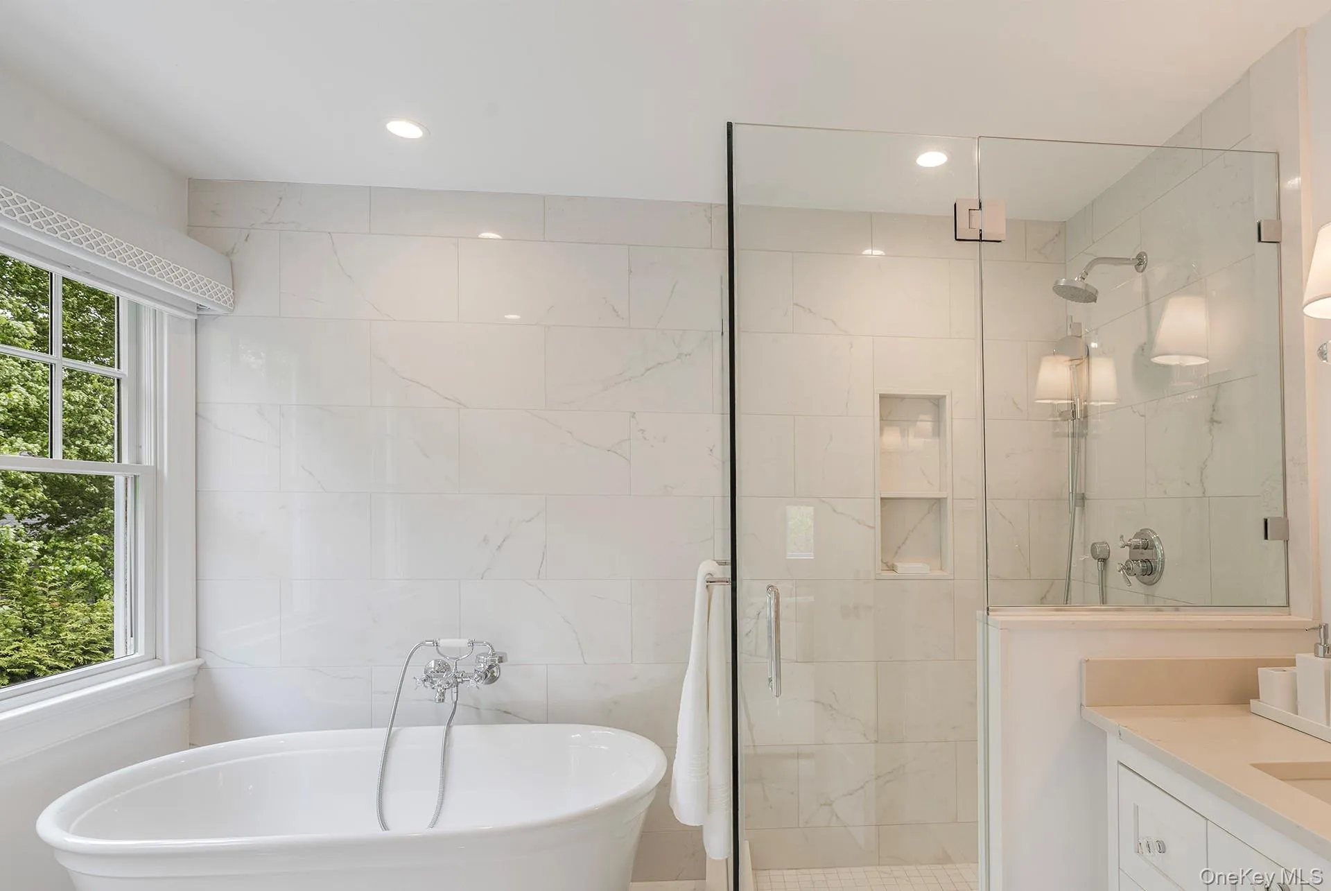 Bathroom with a soaking tub, tile walls, vanity, a marble finish shower, and recessed lighting Bathroom with a soaking tub, tile walls, vanity, a marble finish shower, and recessed lighting