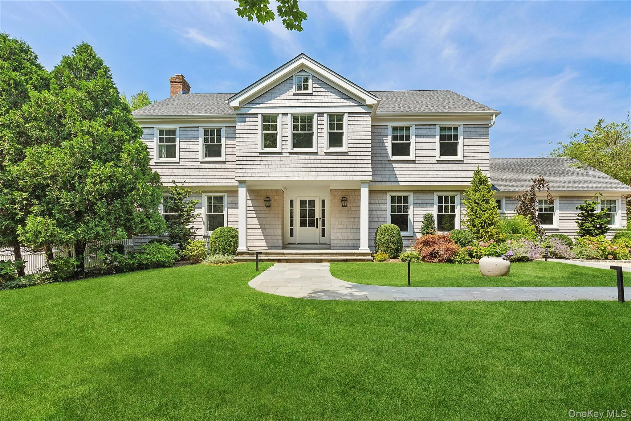 View of front of property with covered porch, a front yard, a chimney, and a shingled roof View of front of property with covered porch, a front yard, a chimney, and a shingled roof