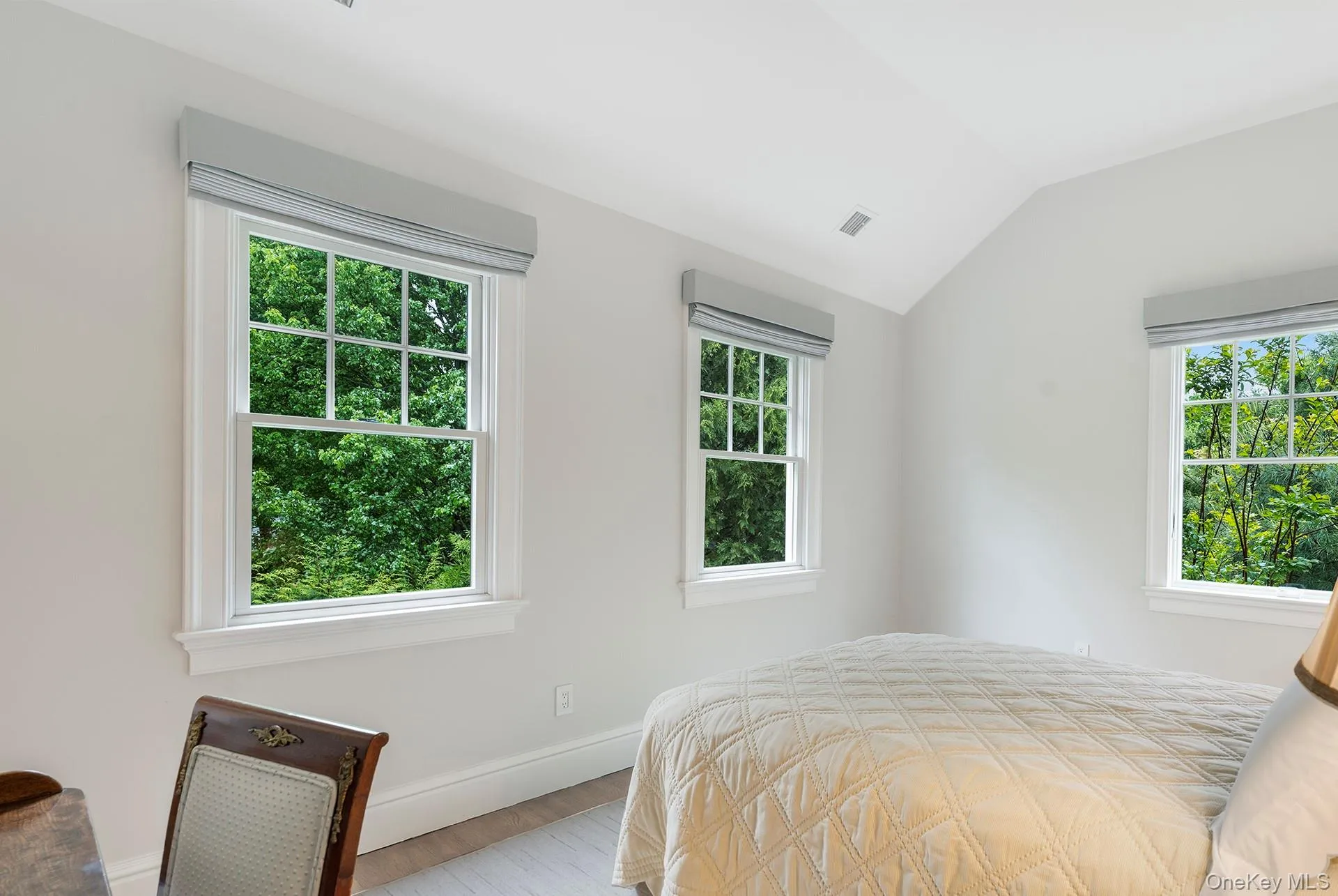 Bedroom with vaulted ceiling and wood finished floors Bedroom with vaulted ceiling and wood finished floors