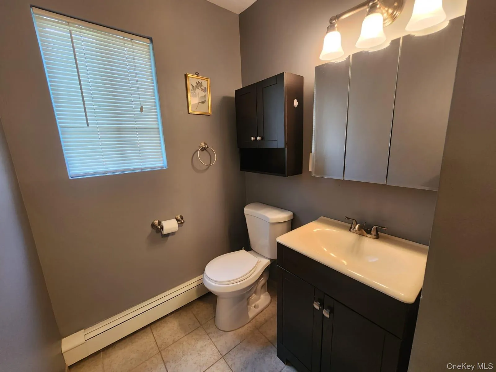 Half bath with a baseboard radiator, tile patterned floors, and vanity Half bath with a baseboard radiator, tile patterned floors, and vanity