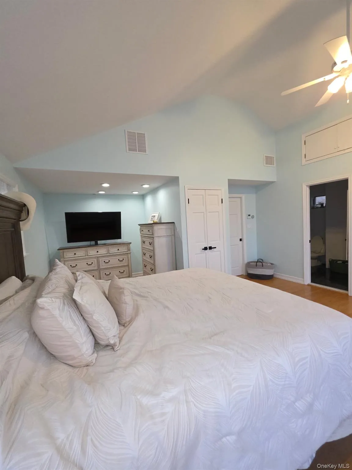Bedroom featuring a ceiling fan, high vaulted ceiling, and wood finished floors Bedroom featuring a ceiling fan, high vaulted ceiling, and wood finished floors