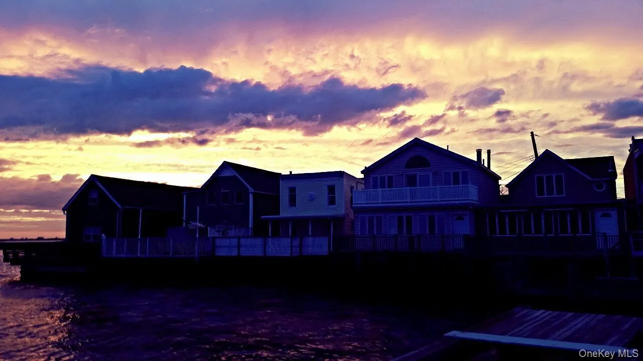 Back of house at dusk with a deck Back of house at dusk with a deck