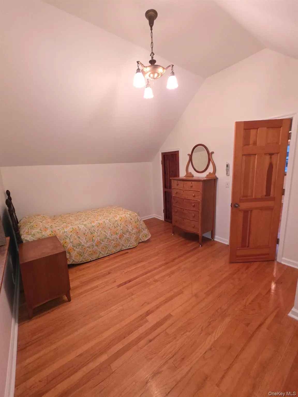 Bedroom with lofted ceiling and light wood-style flooring Bedroom with lofted ceiling and light wood-style flooring