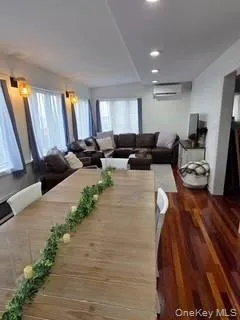 Dining area featuring dark wood-style flooring, recessed lighting, and an AC wall unit Dining area featuring dark wood-style flooring, recessed lighting, and an AC wall unit