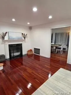 Living room featuring a glass covered fireplace, dark wood finished floors, recessed lighting, and heating unit Living room featuring a glass covered fireplace, dark wood finished floors, recessed lighting, and heating unit