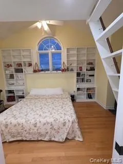 Bedroom with vaulted ceiling, light wood-style floors, and ceiling fan Bedroom with vaulted ceiling, light wood-style floors, and ceiling fan
