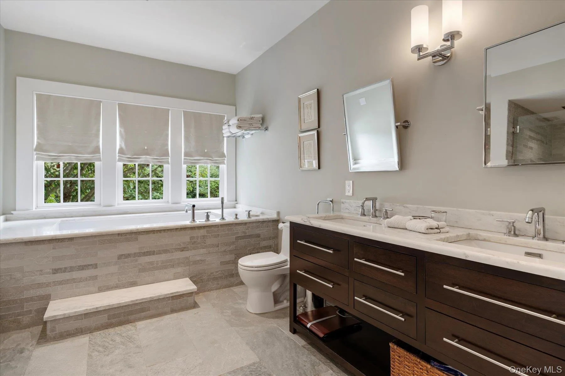 Full bath featuring double vanity, a bath, and light tile patterned floors Full bath featuring double vanity, a bath, and light tile patterned floors