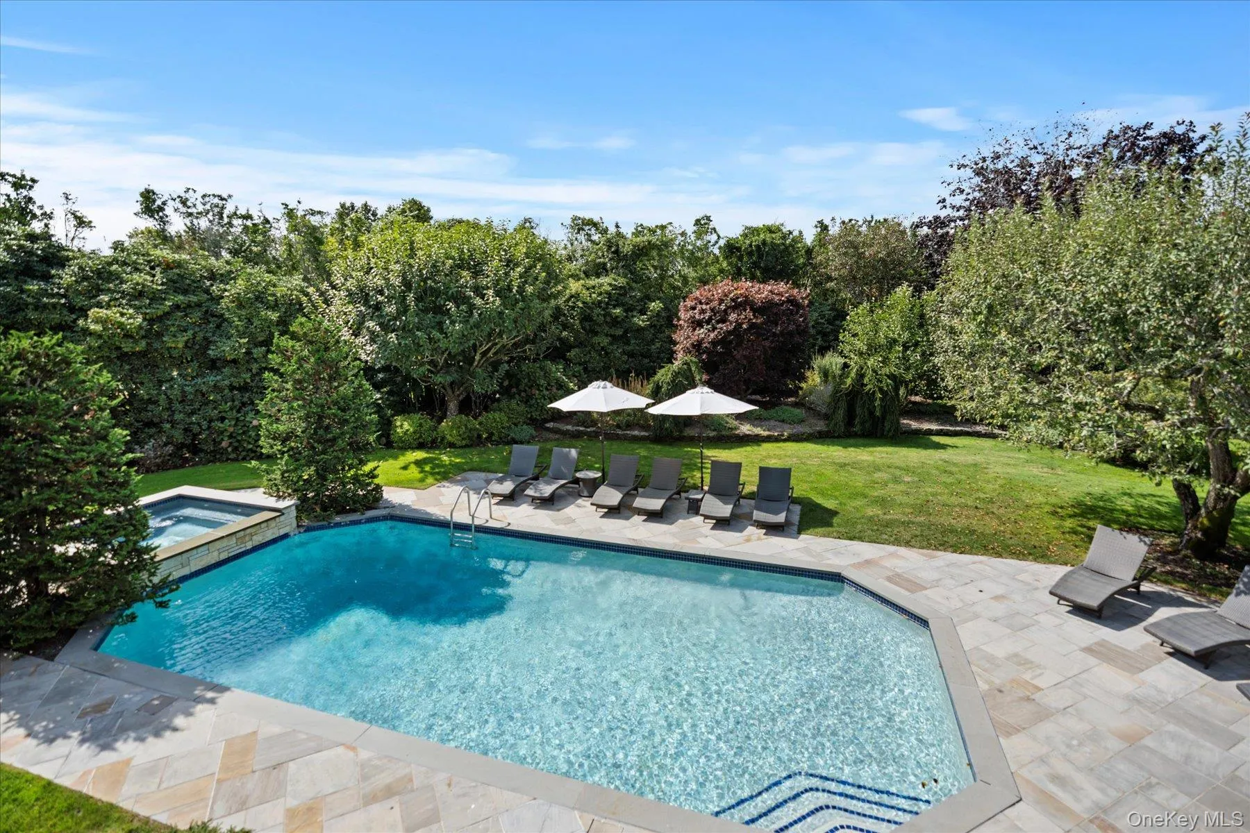 View of swimming pool featuring a yard, a patio area, and a pool with connected hot tub View of swimming pool featuring a yard, a patio area, and a pool with connected hot tub