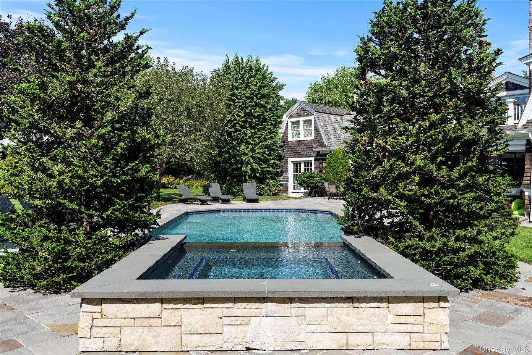 View of pool featuring a patio area and a pool with connected hot tub View of pool featuring a patio area and a pool with connected hot tub