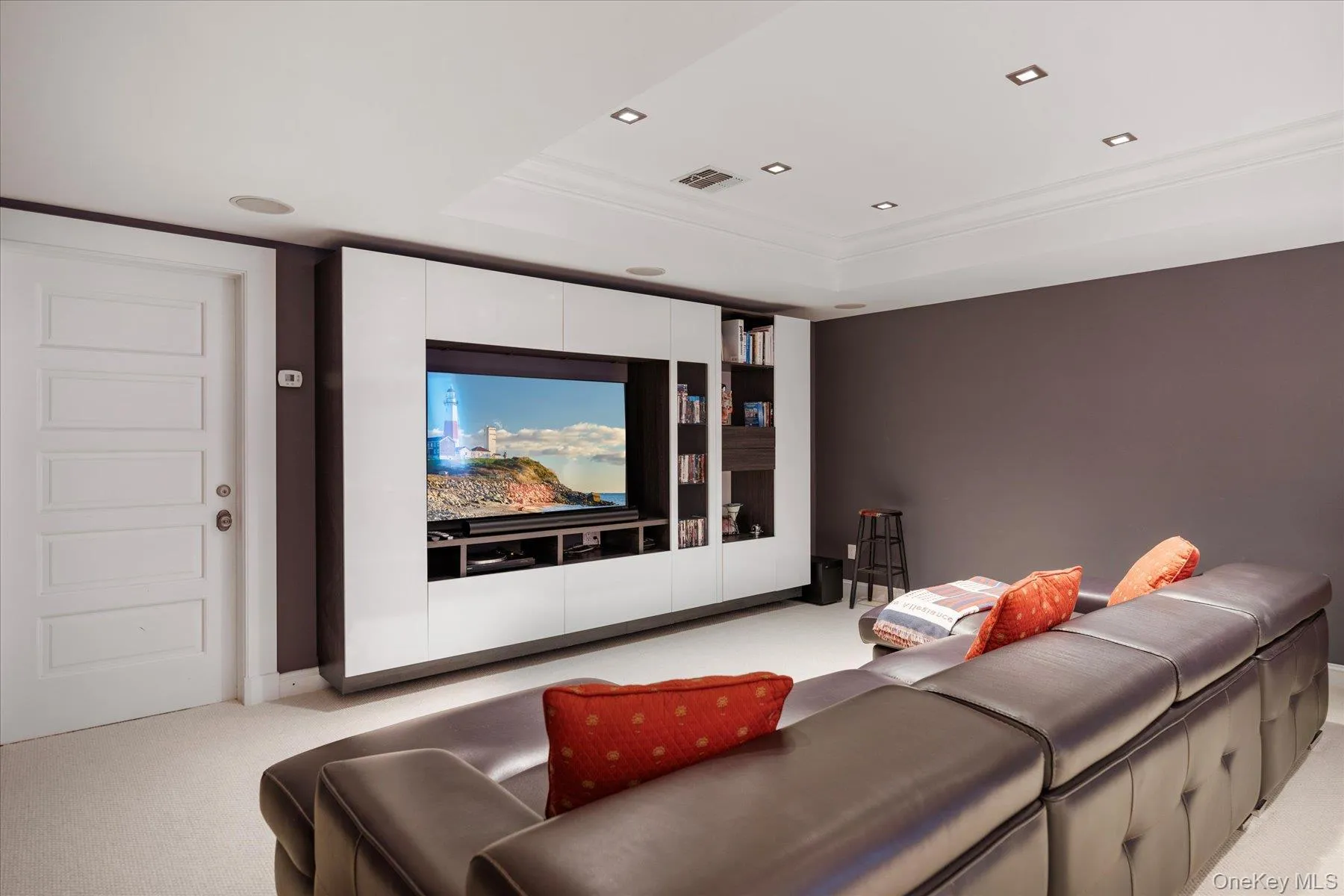 Home theater featuring light colored carpet, a raised ceiling, recessed lighting, and ornamental molding Home theater featuring light colored carpet, a raised ceiling, recessed lighting, and ornamental molding