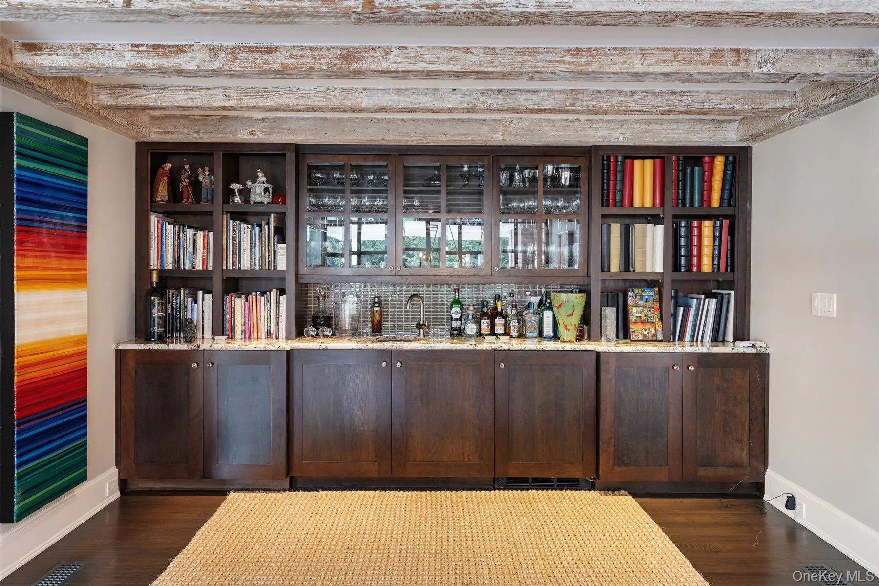 Indoor wet bar featuring open shelves, dark brown cabinets, dark wood-style floors, and light stone countertops Indoor wet bar featuring open shelves, dark brown cabinets, dark wood-style floors, and light stone countertops