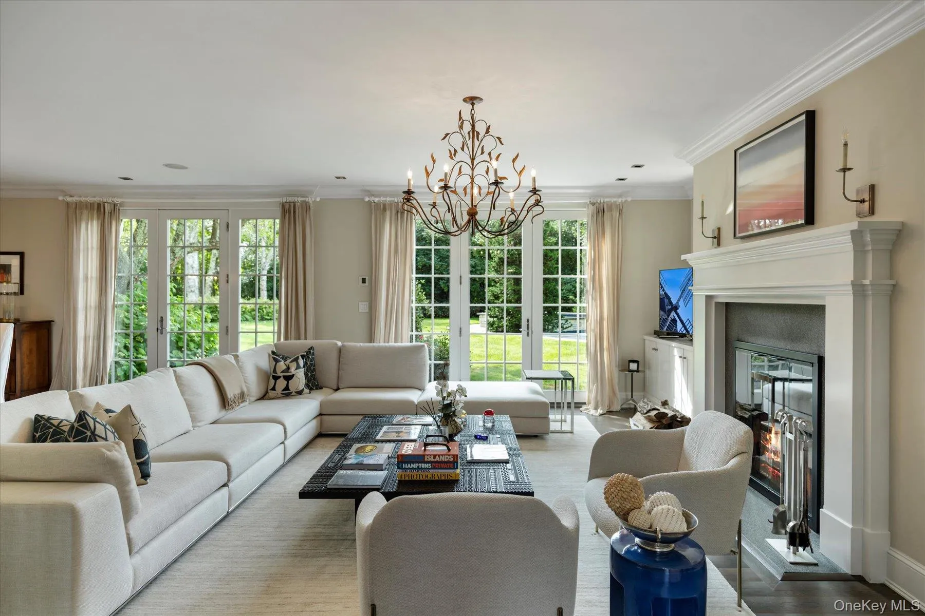 Living area with crown molding, a chandelier, a glass covered fireplace, and wood finished floors Living area with crown molding, a chandelier, a glass covered fireplace, and wood finished floors