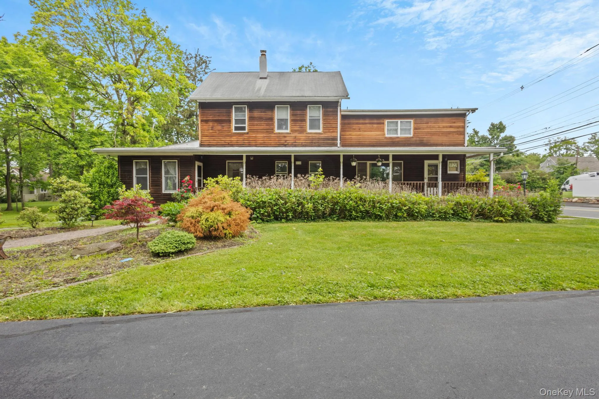 View of front facade featuring a front lawn, a chimney, and a porch View of front facade featuring a front lawn, a chimney, and a porch