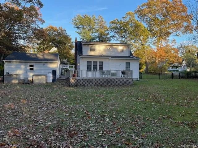 Back of house featuring a chimney and a wooden deck Back of house featuring a chimney and a wooden deck