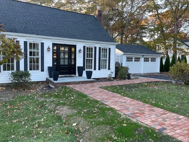 View of front of property with a front yard, a garage, a chimney, and roof with shingles View of front of property with a front yard, a garage, a chimney, and roof with shingles