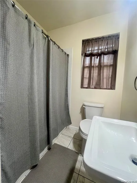 Bathroom with curtained shower and a sink Bathroom with curtained shower and a sink