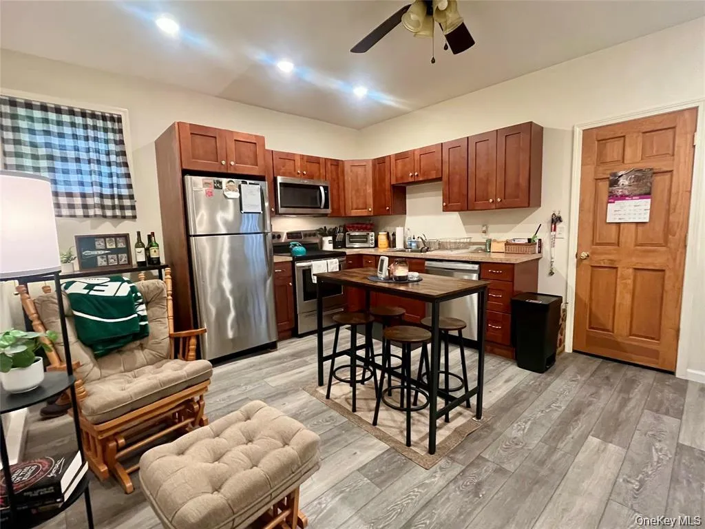 Kitchen featuring stainless steel appliances, light wood-style floors, light countertops, ceiling fan, and recessed lighting Kitchen featuring stainless steel appliances, light wood-style floors, light countertops, ceiling fan, and recessed lighting