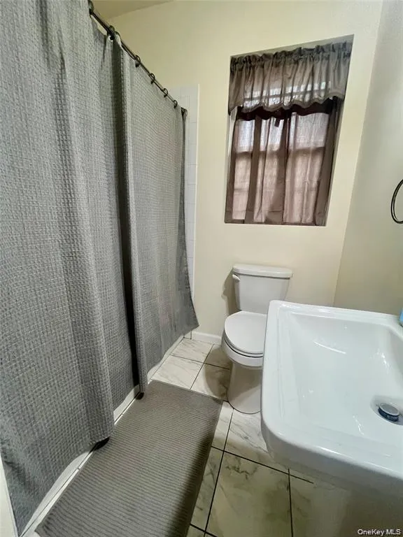 Full bathroom featuring a shower with curtain and toilet Full bathroom featuring a shower with curtain and toilet