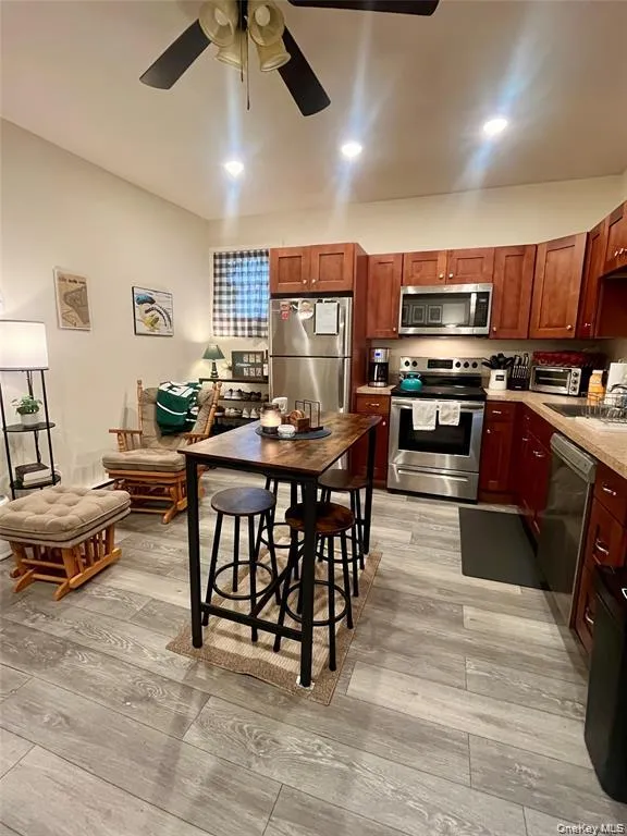 Kitchen featuring appliances with stainless steel finishes, light countertops, light wood-style floors, recessed lighting, and a ceiling fan Kitchen featuring appliances with stainless steel finishes, light countertops, light wood-style floors, recessed lighting, and a ceiling fan