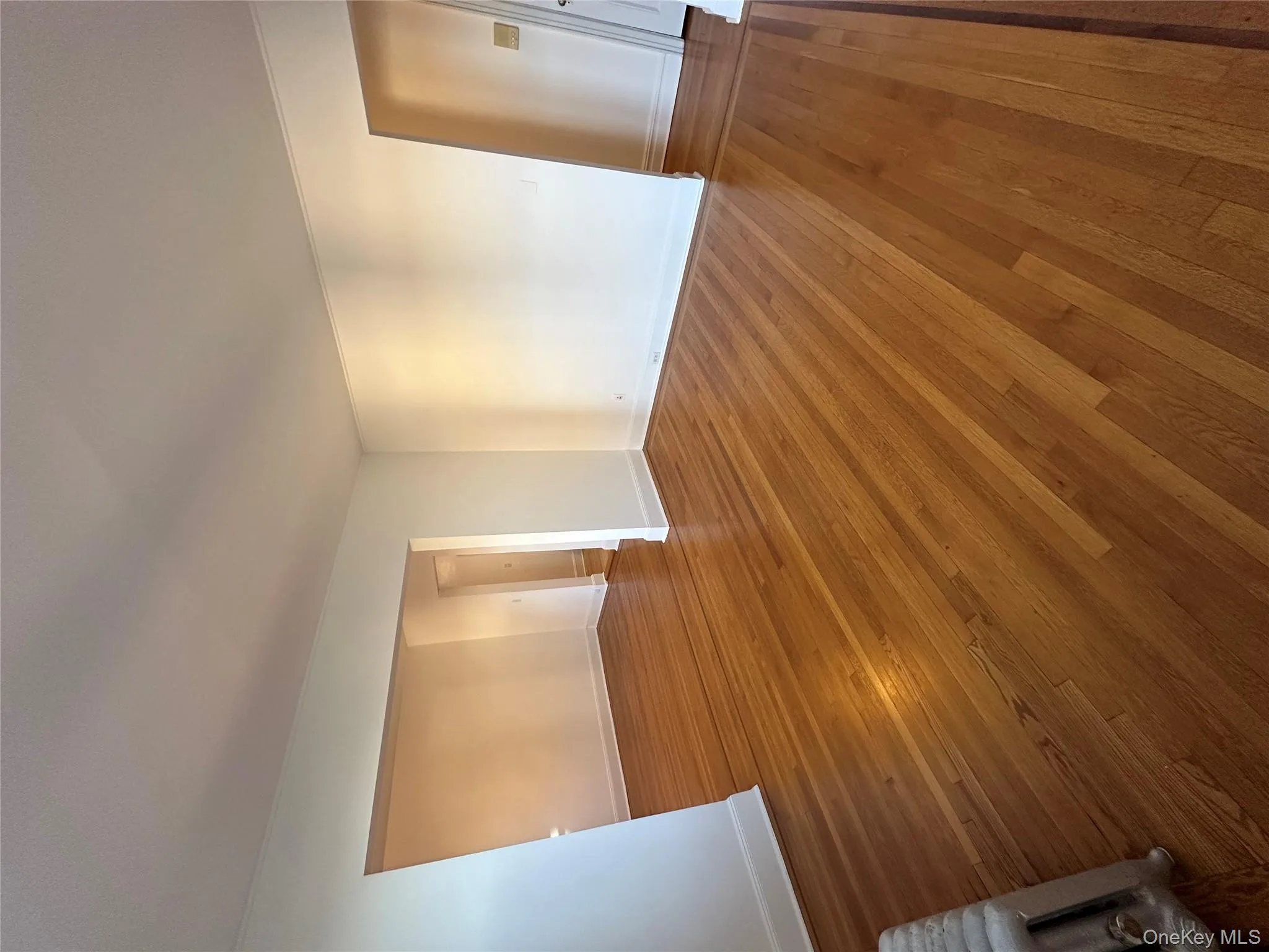 Empty room with hardwood / wood-style flooring and radiator Empty room with hardwood / wood-style flooring and radiator