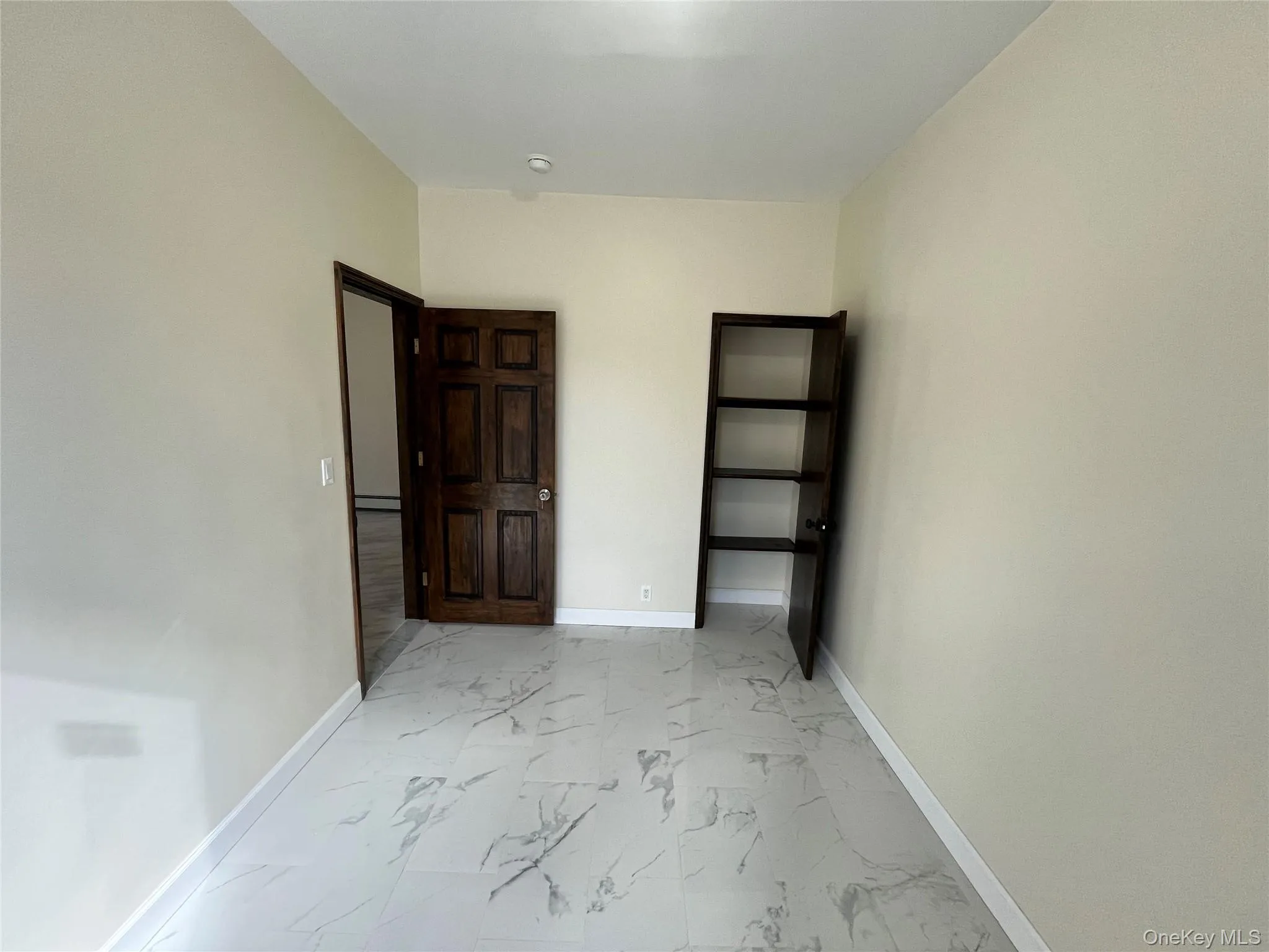 Unfurnished room with baseboards and light marble finish flooring Unfurnished room with baseboards and light marble finish flooring