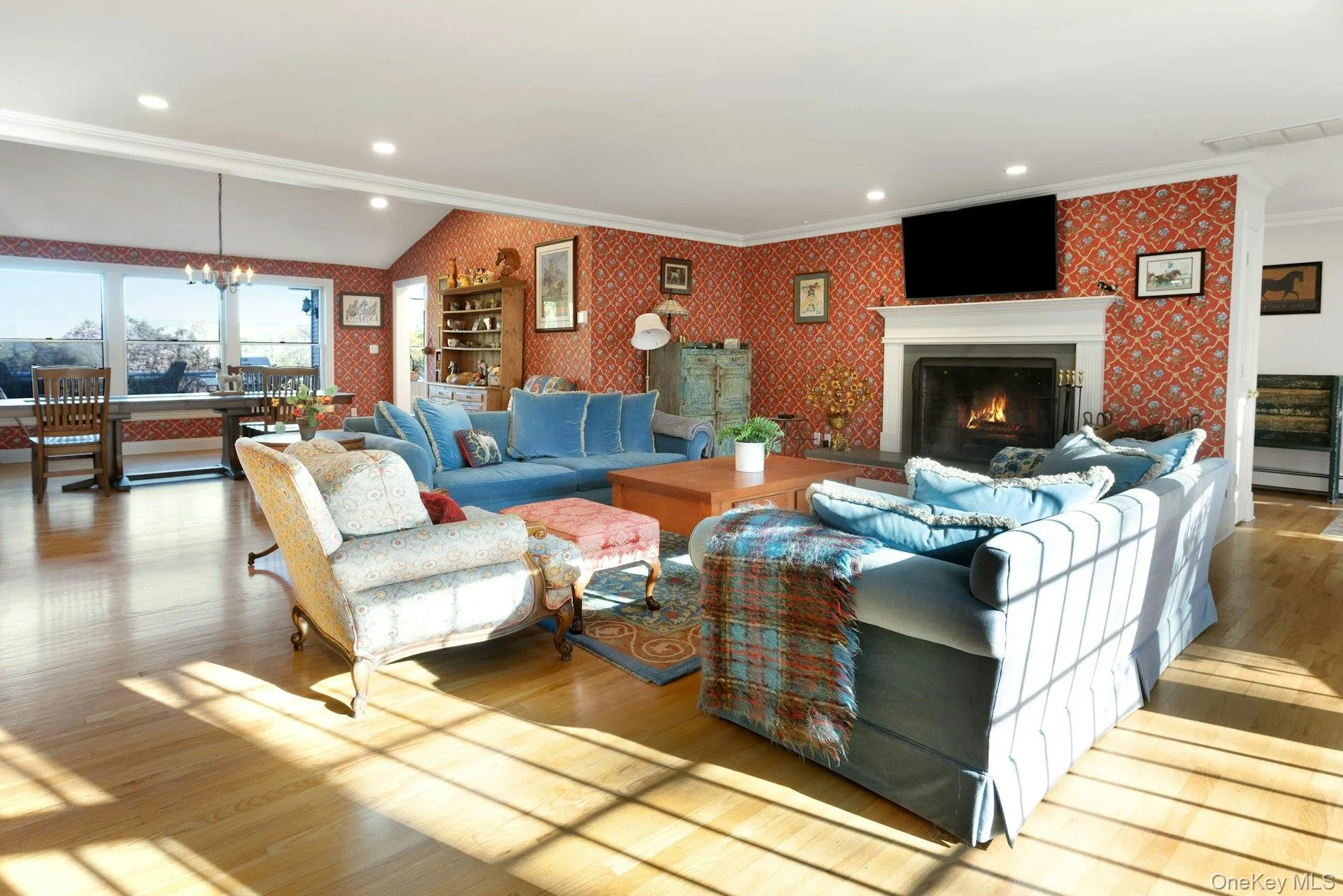 Living room with wallpapered walls, wood-type flooring, a chandelier, crown molding, and recessed lighting Living room with wallpapered walls, wood-type flooring, a chandelier, crown molding, and recessed lighting
