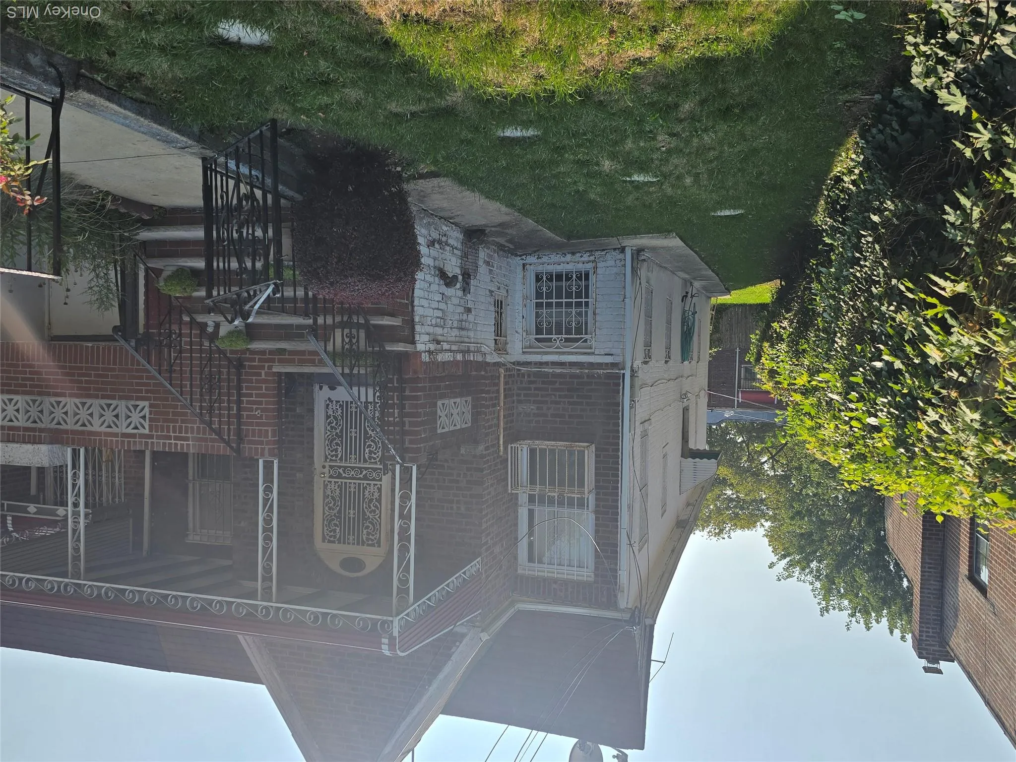 Rear view of property featuring a yard, stone siding, and covered porch Rear view of property featuring a yard, stone siding, and covered porch
