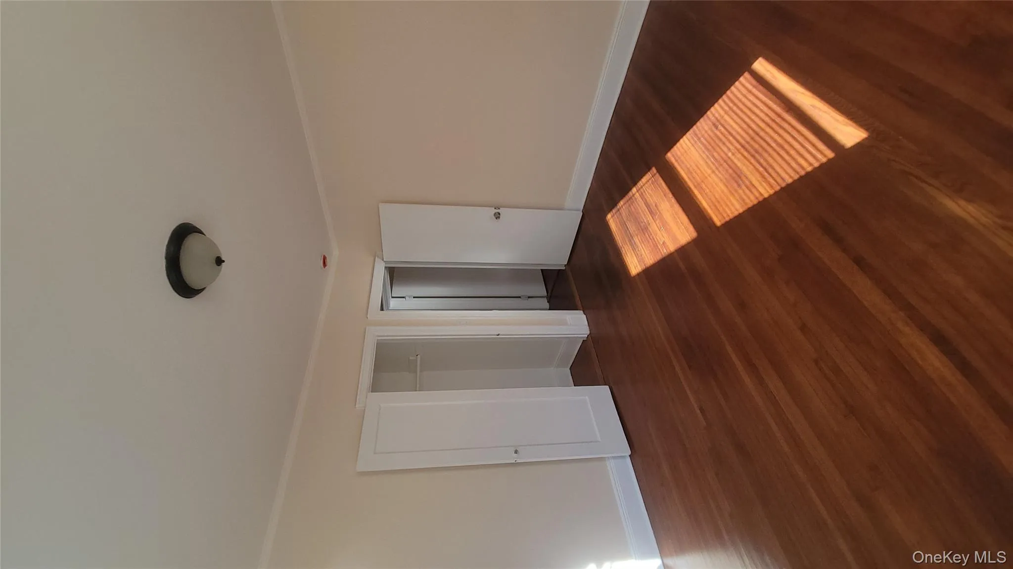 Unfurnished bedroom featuring dark wood finished floors, ornamental molding, and a closet Unfurnished bedroom featuring dark wood finished floors, ornamental molding, and a closet