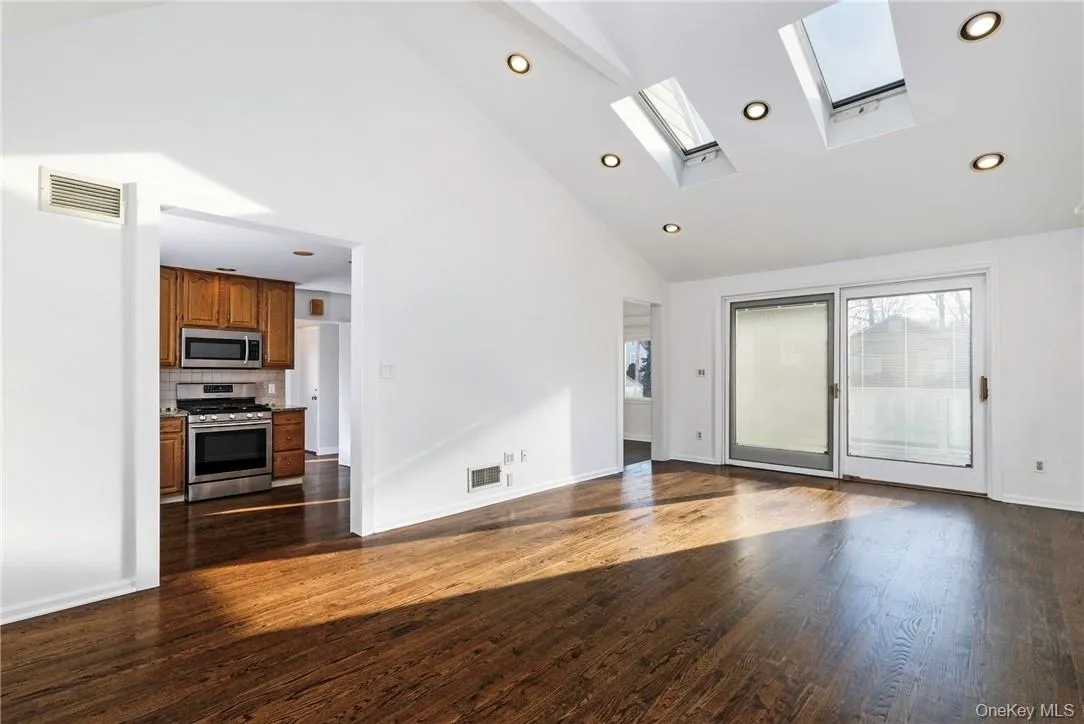 Family room with doors to deck, open to kitchen and dining room Family room with doors to deck, open to kitchen and dining room