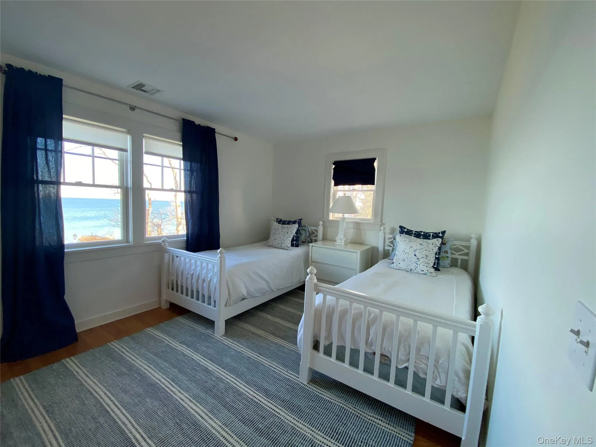 Bedroom featuring wood finished floors and baseboards Bedroom featuring wood finished floors and baseboards